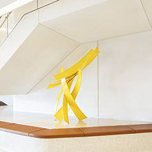 large yellow modern sculpture in a lobby
