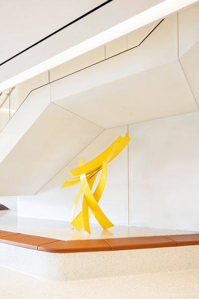 large modern yellow metal sculpture in a lobby
