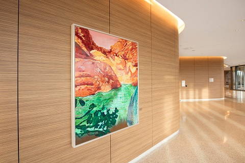 brightly colored artwork with bold orange and green hanging on a wall